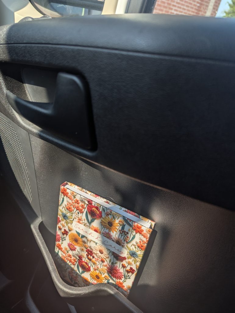 Photo of notebook tucked inside of a car's seat pocket.