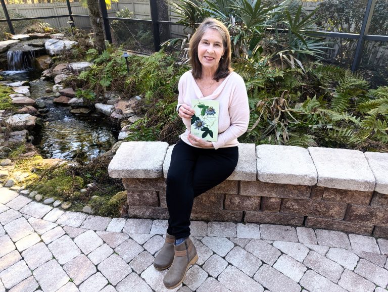 A woman sitting on a bench holding a book.